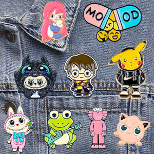 Assorted cartoon character lapel pins (SpongeBob, Minions, basketball, frog, pig) in various colors, arranged on a white background.